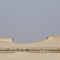 Richard Serra's East-West/West-East Rises in the Qatari Desert “East-West/West-East” / Richard Serra. Image © Nelson Garrido